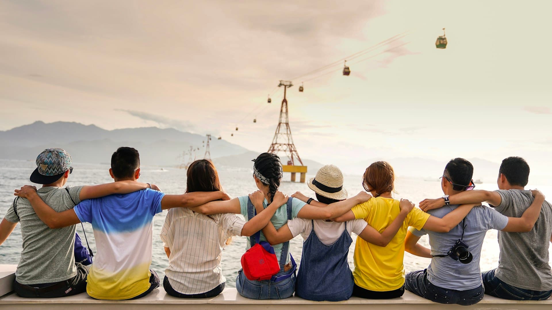 Group of diverse friends celebrating together with hands raised in community